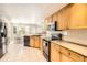 Bright kitchen with natural wood cabinets, and adjacent dining area offers a functional and inviting space at 12705 Kalamath Ct, Westminster, CO 80234
