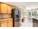 Bright eat-in kitchen with stainless steel refrigerator and tile flooring adjacent to light-filled breakfast nook at 12705 Kalamath Ct, Westminster, CO 80234