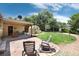 Landscaped backyard with a covered patio, greenhouse, mature trees, and green lawn at 5067 S Mabre Ct, Littleton, CO 80123