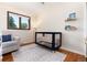 Charming Bedroom featuring a blue crib, neutral tones, and a comfortable chair at 5067 S Mabre Ct, Littleton, CO 80123