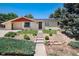 Inviting single-story home with vibrant landscaping, concrete walkway, and a classic neutral exterior at 5067 S Mabre Ct, Littleton, CO 80123