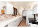 Efficient kitchen featuring white cabinetry, modern appliances, and ample counter space at 5067 S Mabre Ct, Littleton, CO 80123