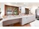 Bright kitchen features white cabinets, a tiled backsplash, and natural light from multiple windows at 5067 S Mabre Ct, Littleton, CO 80123