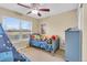 Cozy bedroom with a window, blue bed and furniture and playful decorations at 17216 E Trailmaster Dr, Parker, CO 80134