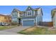 Beautiful two-story home featuring a blue exterior, well-manicured lawn, and attached two-car garage at 17216 E Trailmaster Dr, Parker, CO 80134