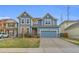 Charming two-story home with a blue exterior, a spacious driveway, and well-maintained landscaping at 17216 E Trailmaster Dr, Parker, CO 80134