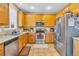 Modern kitchen with stainless steel appliances, oak cabinetry, and tile flooring at 17216 E Trailmaster Dr, Parker, CO 80134