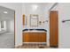 Bathroom features a single sink vanity with wooden cabinets and a framed mirror at 5325 Allison St, Arvada, CO 80002