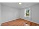 A bright bedroom with wood-look flooring, white walls, and a window with backyard views at 5325 Allison St, Arvada, CO 80002