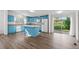 Bright, airy kitchen featuring blue cabinets, white appliances, an island, and sliding glass doors to the backyard at 5325 Allison St, Arvada, CO 80002
