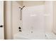 Bright bathroom features a white tile surround and a relaxing soaking tub with a matte black shower head at 7408 S Alkire St # 301, Littleton, CO 80127