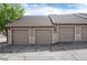 Attached garages featuring individual doors, stone accents, and private parking spaces at 7408 S Alkire St # 301, Littleton, CO 80127