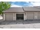 Attached garages featuring individual doors, stone accents, and private parking spaces at 7408 S Alkire St # 301, Littleton, CO 80127