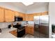 Well-lit kitchen features stainless steel appliances, wood cabinets and stone countertops at 7408 S Alkire St # 301, Littleton, CO 80127