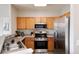 Bright kitchen with stainless steel appliances, wood cabinets and stone countertops at 7408 S Alkire St # 301, Littleton, CO 80127