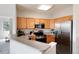 Bright kitchen featuring stainless steel appliances, oak cabinets, and stone countertops at 7408 S Alkire St # 301, Littleton, CO 80127