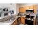 Open kitchen with stainless appliances, stone countertops and adjoined living room with fireplace at 7408 S Alkire St # 301, Littleton, CO 80127