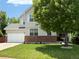 Charming two-story home features a well-manicured lawn, brick accents, light gray siding, and a classic white two car garage door at 8010 Raspberry Dr, Frederick, CO 80504