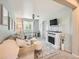 Inviting living room featuring a charming fireplace, comfortable seating, and a bright workspace with natural light at 8010 Raspberry Dr, Frederick, CO 80504