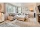 A comfortable living room with a plush sectional sofa, fireplace, and lots of natural light from the large window at 8010 Raspberry Dr, Frederick, CO 80504