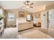 Bright main bedroom features a tufted bed, sitting area, and large windows for ample natural light at 8010 Raspberry Dr, Frederick, CO 80504
