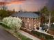 Aerial view of brick home showcasing mature trees, patio seating, lush yard, and neighborhood at 201 S Lafayette St, Denver, CO 80209