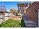 Brick home featuring a backyard with lush green grass, a retaining wall and steps leading to the yard at 201 S Lafayette St, Denver, CO 80209