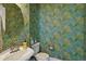 This half-bath features designer wallpaper and an elegant pedestal sink with chrome fixtures, adding a touch of charm at 201 S Lafayette St, Denver, CO 80209