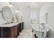 Elegant bathroom featuring dual sinks, marble countertops, and a freestanding vintage tub at 201 S Lafayette St, Denver, CO 80209