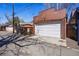 Detached brick garage featuring a white garage door and alley access at 201 S Lafayette St, Denver, CO 80209