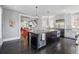 A kitchen with a large island is open to a dining area and features stainless steel appliances and dark hardwood floors at 201 S Lafayette St, Denver, CO 80209