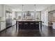 Open kitchen with large island, stainless steel appliances, and dark hardwood floors at 201 S Lafayette St, Denver, CO 80209
