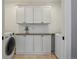 Functional laundry room with appliances, white shaker cabinets, and granite countertop space at 201 S Lafayette St, Denver, CO 80209