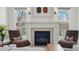 The main bedroom sitting area features a fireplace, vintage leather chairs, and natural light creating a cozy retreat at 201 S Lafayette St, Denver, CO 80209