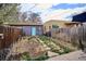 Backyard featuring a blue door, grass and stone path, and fenced perimeter at 3130 N Race St, Denver, CO 80205