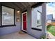 Close-up of the covered front porch featuring gray brick, red door, and mailbox at 3130 N Race St, Denver, CO 80205