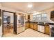 Bright kitchen featuring stainless steel appliances, tile floors, oak cabinets, and black countertops at 2501 S Gray Ct, Lakewood, CO 80227