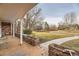 Inviting covered porch with brick accents, a bench, and a view of the landscaped front yard at 2501 S Gray Ct, Lakewood, CO 80227