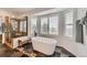 Luxurious bathroom with soaking tub, walk-in shower, tiled floors, and large windows with views at 6017 Merchant Pl, Parker, CO 80134