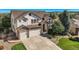Two-story house with stone accents, three-car garage, and landscaped yard at 6017 Merchant Pl, Parker, CO 80134