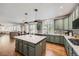 Open kitchen with large island, green cabinets, and views to the living room at 6017 Merchant Pl, Parker, CO 80134