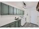 Well-appointed laundry room with ample counter space, cabinetry, stylish flooring, and modern appliances at 6017 Merchant Pl, Parker, CO 80134
