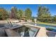 Luxurious pool and spa area with a waterfall, lounge chairs, and lush greenery, ideal for outdoor relaxation at 6017 Merchant Pl, Parker, CO 80134