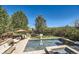 Resort-style pool with waterfall feature, sun loungers, and lush landscaping, creating a private oasis at 6017 Merchant Pl, Parker, CO 80134