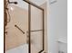 Bathroom featuring a shower with bronze fixtures, sliding glass door, and accessible grab bar at 5765 N Genoa Way # 1-103, Aurora, CO 80019