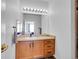 Bathroom featuring a mirror, vanity, hardwood floors, and warm lighting at 5765 N Genoa Way # 1-103, Aurora, CO 80019