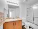 A bright bathroom with a vanity, large mirror and shower behind a glass door at 5765 N Genoa Way # 1-103, Aurora, CO 80019