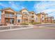 Apartment complex exterior featuring balconies, tidy landscaping, and designated parking spaces at 5765 N Genoa Way # 1-103, Aurora, CO 80019