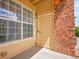 Exterior view of the front door framed by brick and a large window, creating a welcoming entrance at 5765 N Genoa Way # 1-103, Aurora, CO 80019