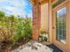 Inviting front porch with brick pillars, lush greenery, and a storm door at 5765 N Genoa Way # 1-103, Aurora, CO 80019